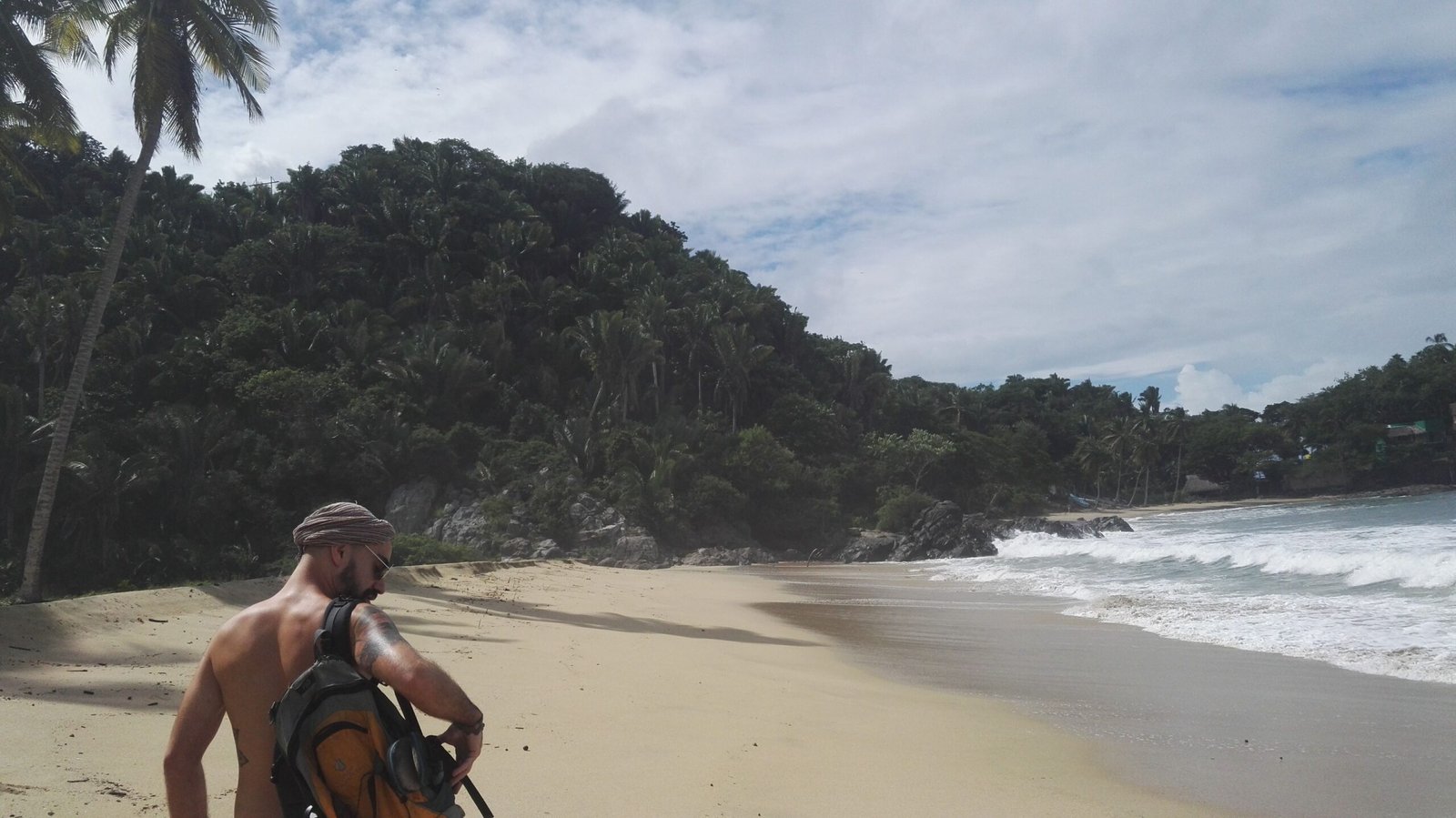lonely bay framed by green hills and palm trees