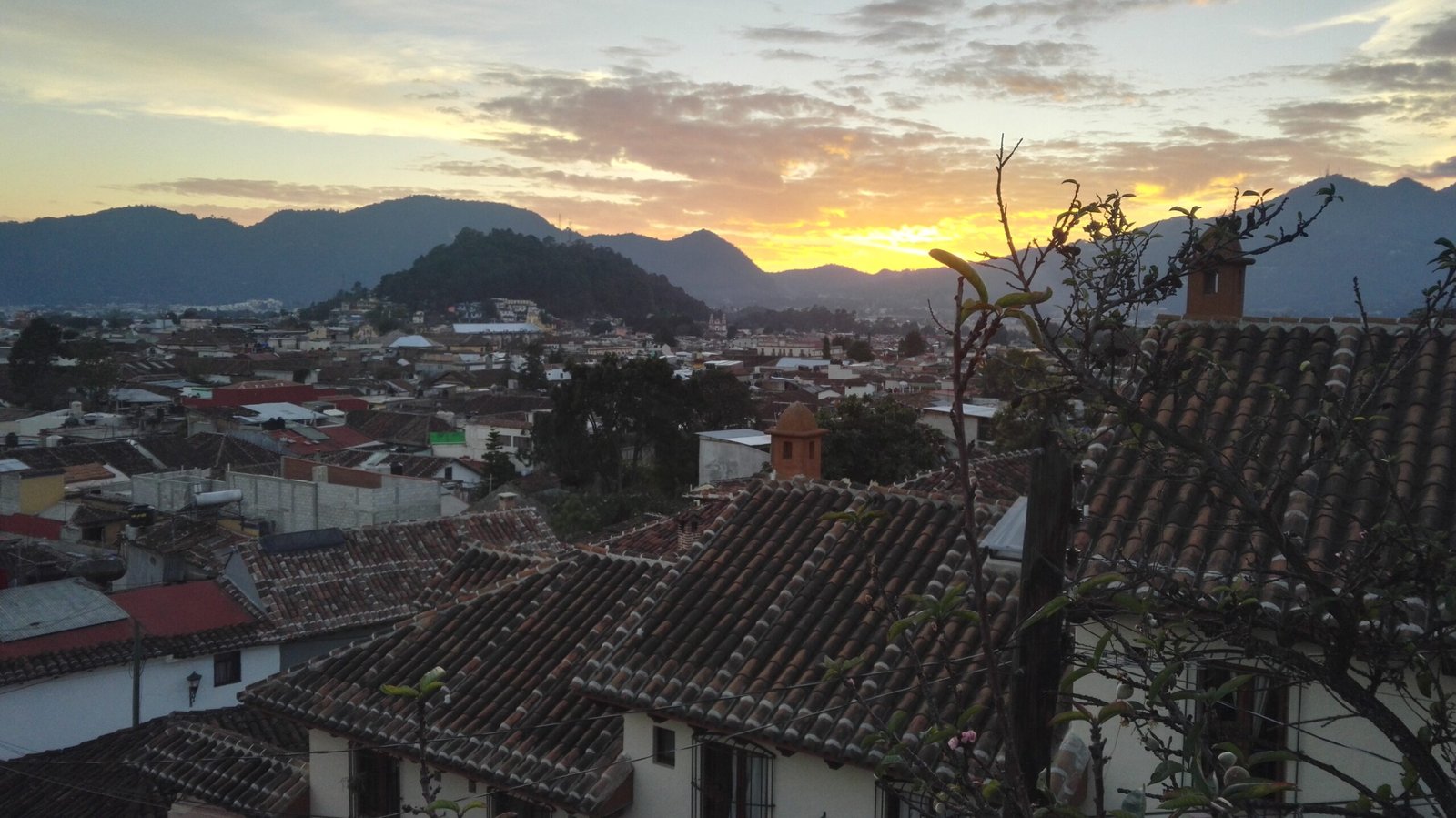 view over the city at sunset, roofs and mountains