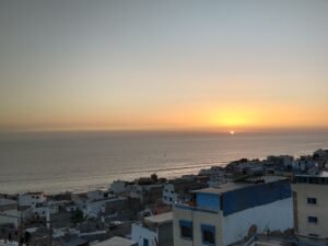 sunset from the upper village looking over houses and the ocean